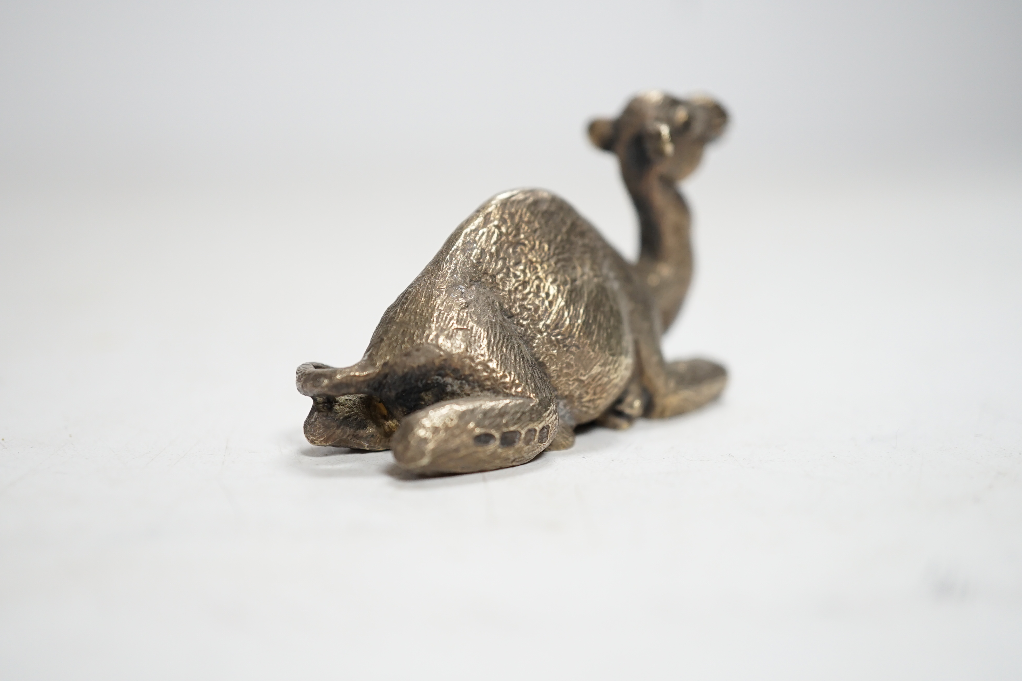 An Elizabeth II miniature silver model of a recumbent camel, by Stuart Devlin, London, 1979, length 58mm.